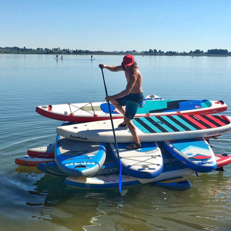 A paddleboarder riding stacked paddleboards