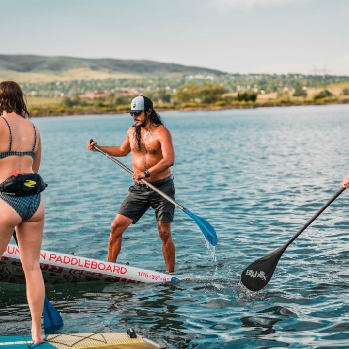 a group of people standing next to a body of water