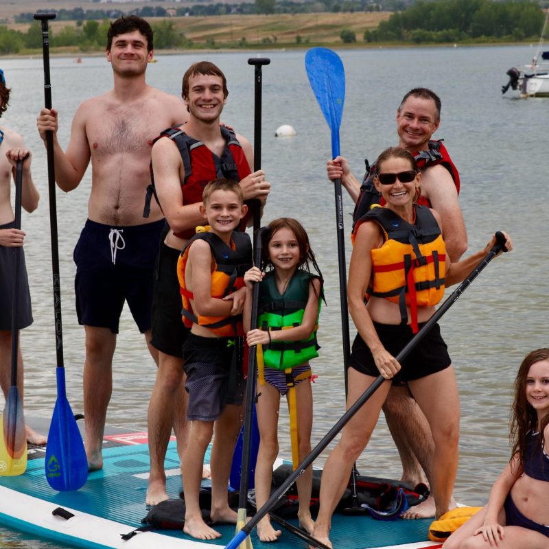 a group of people standing next to a body of water