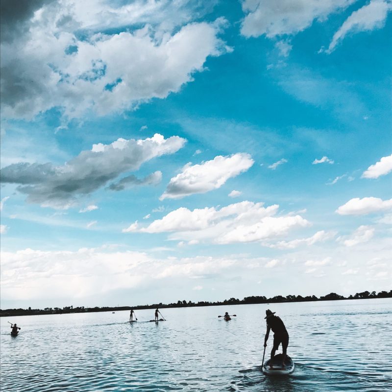 a group of people standing next to a body of water
