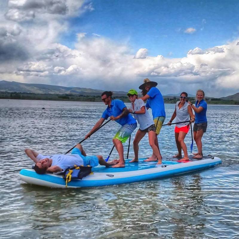 a group of people riding on the back of a boat in the water