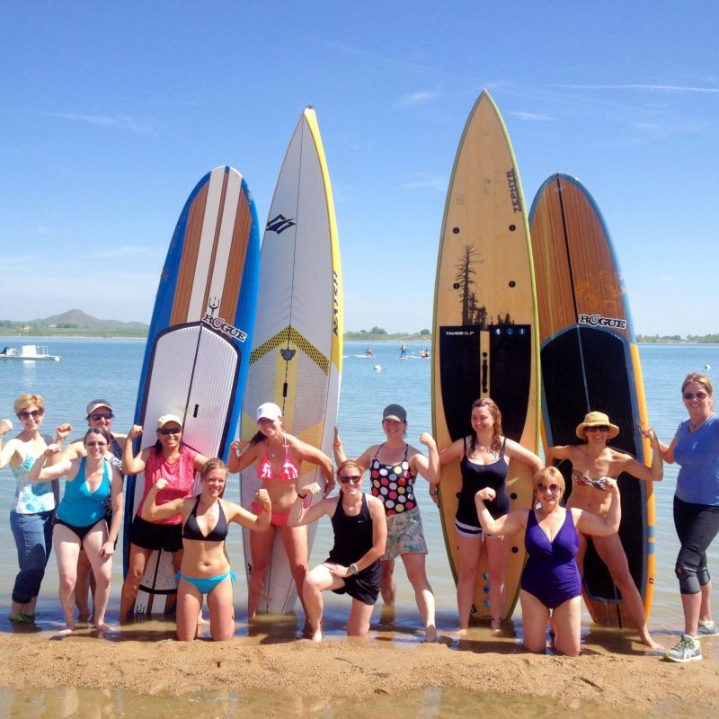 a group of people standing on a beach posing for the camera