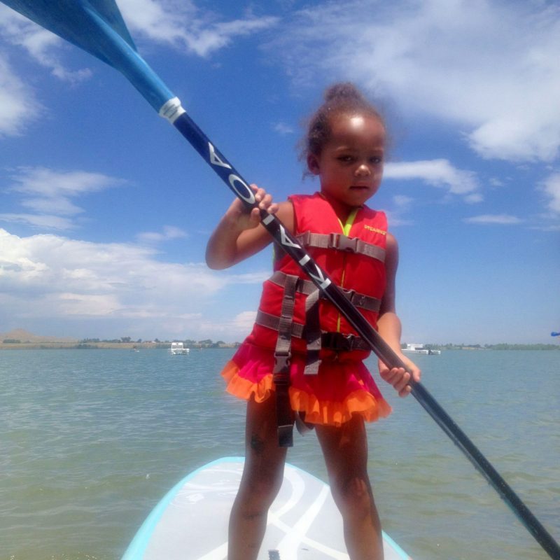 a young boy riding a boat on a body of water