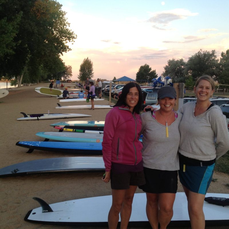a group of people standing on a beach posing for the camera