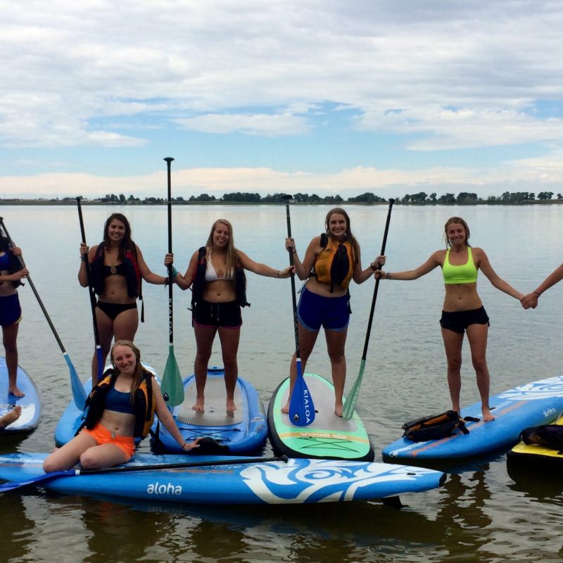 a group of people riding on the back of a boat in the water