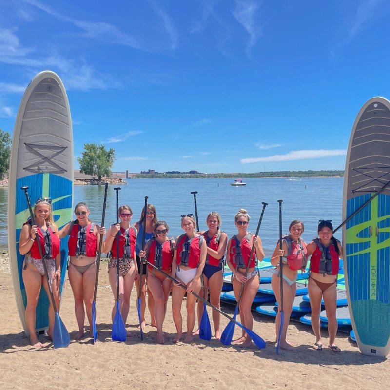 a group of people standing on a beach posing for the camera