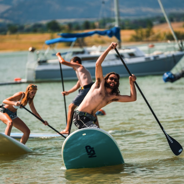 a group of people riding on the back of a boat in the water