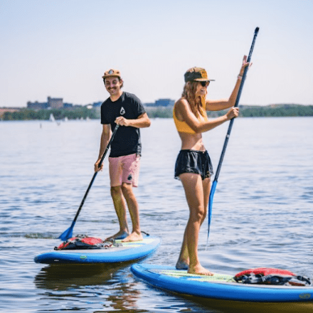 a little girl riding on the back of a boat in the water